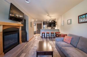 ein Wohnzimmer mit einem Sofa und einem Kamin in der Unterkunft Zephyr Mountain Lodge Premium-Rated 1102 in Winter Park