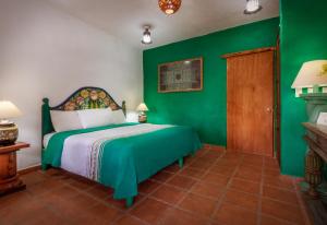 1 dormitorio con paredes verdes y 1 cama en Eco Hotel Ixhi en Pátzcuaro