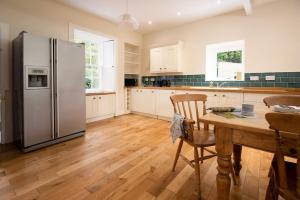 a kitchen with a wooden table and a refrigerator at The White House in Duns