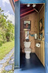 a bathroom with a toilet in a wooden house at Hawaiian Balinese Temple House in Pahoa