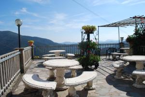 eine Terrasse mit Tischen und Stühlen auf dem Balkon in der Unterkunft Hotel Mirador in Aulla