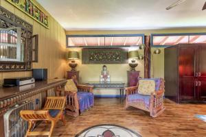 a living room with a bar and chairs and a table at Hawaiian Balinese Temple House in Pahoa