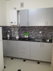 a kitchen with white cabinets and a brick wall at ERA Hotel in Gyumri