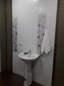 a white bathroom with a sink and a towel at ERA Hotel in Gyumri