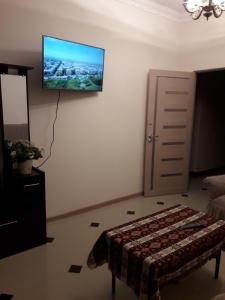 a living room with a bed and a television on the wall at ERA Hotel in Gyumri