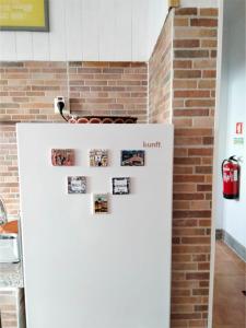 a refrigerator in a kitchen with photos on it at Casa Terra Cota - Almada in Almada