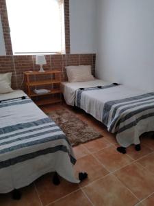 a bedroom with two beds and a window at Casa Terra Cota - Almada in Almada