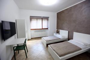 a bedroom with two beds and a desk and a computer at Casa Michela in LʼAquila