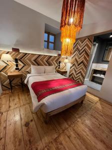 Un dormitorio con una cama grande y una lámpara de araña. en Casa Tunki, en Cusco