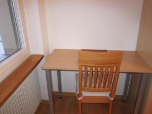 a wooden table with a wooden chair next to a window at 2.5-Zimmer-Wohnung Balkon freie See- und Bergsicht, Garage PPe in Engelberg