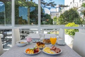 einen Frühstückstisch mit Speisen und Getränken auf dem Balkon in der Unterkunft Hotel Arte del Rey in Pinamar