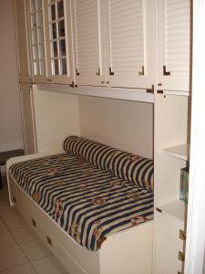 利多迪卡馬約雷的住宿－Mimi House，一张小床,位于一个白色橱柜的房间