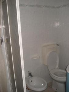 a white bathroom with a toilet and a sink at Mimi House in Lido di Camaiore