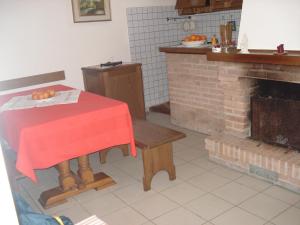 a kitchen with a table and a brick fireplace at Mimi House in Lido di Camaiore
