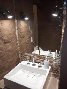 y baño con lavabo blanco y espejo. en Departamento para relax y descanso en Luján de Cuyo