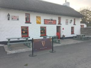a white building with picnic tables in front of it at Lakeview farm in Castletown