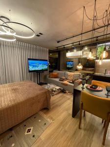 a bedroom with a bed and a living room at Flat Moderno e decorado Lapa-RJ in Rio de Janeiro
