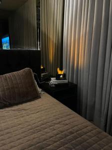 a bedroom with a bed and a window with curtains at Flat Moderno e decorado Lapa-RJ in Rio de Janeiro