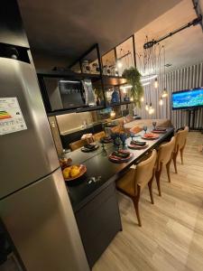 a kitchen and dining room with a table and a refrigerator at Flat Moderno e decorado Lapa-RJ in Rio de Janeiro