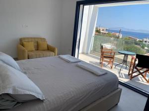 a bedroom with a bed and a balcony with a view at Souvala /Aegina. Excellent location Luxury villa. in Vathí