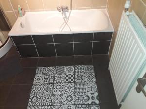 a bath tub with a black and white tile floor at Spacious duplex in Brussels Historical Center in Brussels