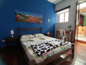 une chambre avec un lit et un mur bleu dans l'établissement Habitaciones privadas en Caracol Casa Turistica, à San Gil 10 autres photos