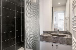 een badkamer met een wastafel en een douche bij Appartement L'Îlot au centre du port de Saint Martin in Saint-Martin-de-Ré