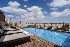 a large swimming pool on the roof of a building at King David Penthouse with private pool in Jerusalem