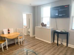 a dining room with a table and a screen on the wall at Modern cozy 1BD/1BA Apt in Federal Hill in Baltimore