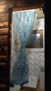 una cortina azul y blanca en la esquina de un baño en Yurta con uso piscina e vista meravigliosa, en Dicomano