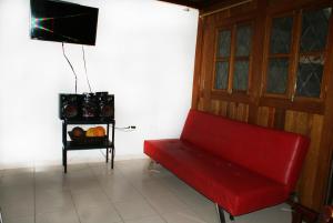 a red couch in a room with a table at Cabaña Parejas y Familias Condominio Campestre cerca Rodadero con Piscinas in Santa Marta