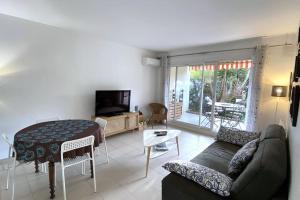 a living room with a couch and a table at Rabiac - Charming 1 bedroom with private garden in Antibes