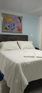 a large white bed with a painting on the wall at Casa Jac in Bucaramanga