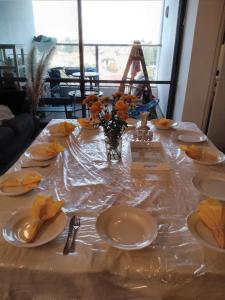 una mesa con platos y un jarrón de flores. en דירה מהממת ברעננה לשומרי שבת וכשרות, en Raanana