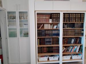 a book shelf filled with lots of books at דירה מהממת ברעננה לשומרי שבת וכשרות in Ra‘ananna