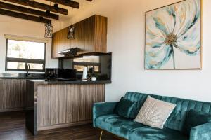 uma sala de estar com um sofá verde e uma cozinha em Oasis 444 em San Marcos