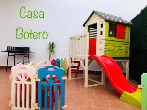 a play area with a slide and a play house at Casa Botero in El Bosque