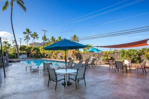 a table with chairs and an umbrella next to a pool at Holualoa Bay Villas#105 in Kailua-Kona