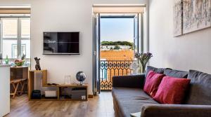 a living room with a couch and a balcony at Chiado Apartment with View to the Castle in Lisbon