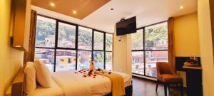 una camera con letto e ampie finestre di Hotel Raices Machupicchu a Machu Picchu