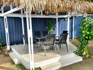 eine Terrasse mit einem Tisch und Stühlen unter einem Strohdach in der Unterkunft Bua Bed & Breakfast in Nadi