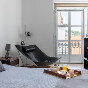 a bedroom with a piano and a tray of food on a bed at Chiado Apartment with View to the Castle in Lisbon