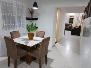 uma mesa de jantar e cadeiras com uma planta em Casa para temporada c/ ar condicionado, próximo da praia e do Beco das Garrafas em Prado