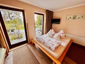 a bedroom with a bed and a large window at Penzion Zrzka in Kořenov