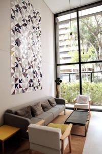 a living room with a couch and a large window at 92 New studio next Paulista Av, fast wifi and balcony in Sao Paulo