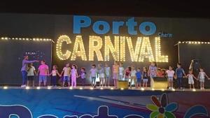 Porto Sharm hosts & apartments في شرم الشيخ: مجموعة اطفال واقفين على المسرح امام الاشارة