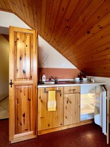 eine Küche mit einem Waschbecken und einer Holzdecke in der Unterkunft Penzion Zrzka in Kořenov