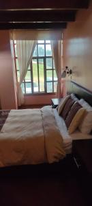 sypialnia z dużym łóżkiem i oknem w obiekcie Hosteria Loma Larga Cayambe w mieście Cayambe