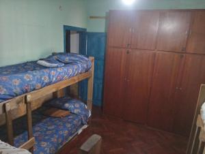 a bedroom with two bunk beds and a wooden cabinet at HOSTEL ATG in Ciudad Lujan de Cuyo