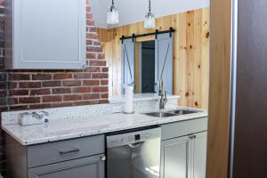 a kitchen with a sink and a brick wall at Lake Winnisquam Getaway in Sanbornton